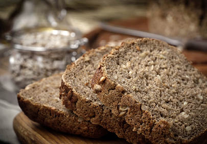 Wholemeal bread with sunflower seeds. Dark light.