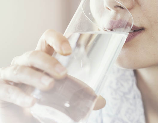 Young woman drinking pure glass of water